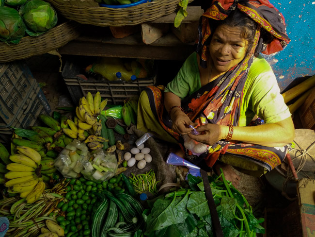 woman selling duck eggs and pumpkin flowers in Kolkata