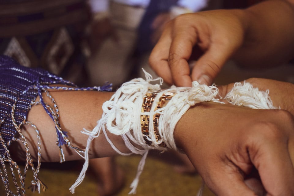 Baci threads tied on guests hand at Luang Prabang, Laos